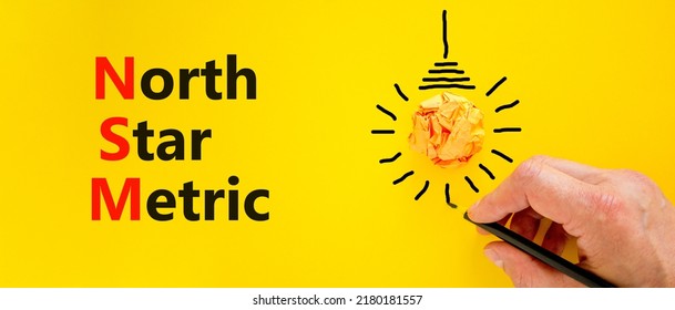 NSM North Star Metric Symbol. Concept Words NSM North Star Metric On Yellow Paper On A Beautiful Yellow Background. Businessman Hand. Business And NSM North Star Metric Concept. Copy Space.