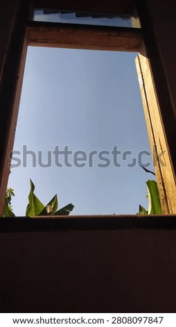 The nuances of the daytime sky from behind the window.