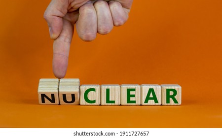 Nuclear or clear symbol. Businessman turns a cube and changes the word 'nuclear' to 'clear'. Beautiful orange background. Nuclear or clear and business concept. Copy space. - Shutterstock ID 1911727657