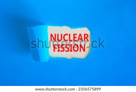 Nuclear fission symbol. Concept words Nuclear fission on beautiful white paper. Beautiful blue paper background. Business science nuclear fission concept. Copy space.