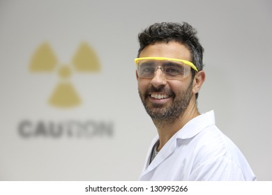 Nuclear Plant Employee Against A Wall With Caution Radioactive Symbol