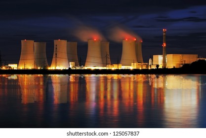 Nuclear power plant by night with reflection