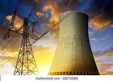 Nuclear power plant with high voltage towers against the sunset