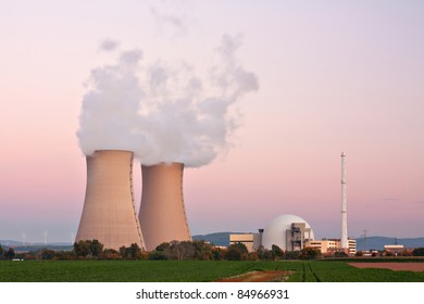 Nuclear power plant at twilight in Grohnde near Hameln in Lower Saxony. At the left are the cooling towers with water vapor, at the right the reactor.