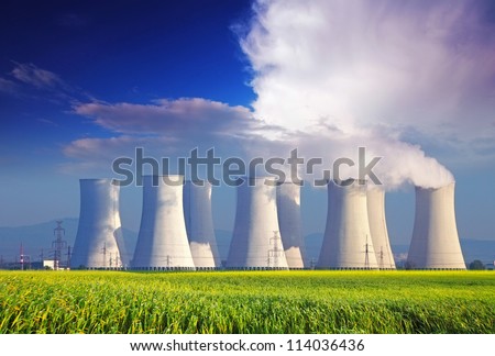 Nuclear power plant with yellow field and big blue clouds