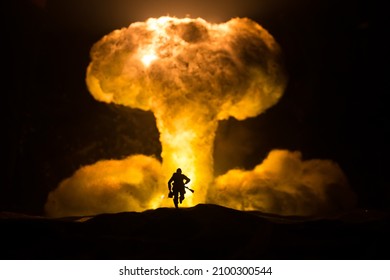 Nuclear war concept. Explosion of nuclear bomb. Creative artwork decoration in dark. Silhouette of soldier standing against giant mushroom cloud of atomic explosion. Selective focus