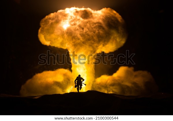 Nuclear war\
concept. Explosion of nuclear bomb. Creative artwork decoration in\
dark. Silhouette of soldier standing against giant mushroom cloud\
of atomic explosion. Selective\
focus