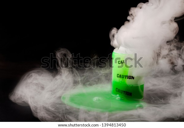 Nuclear waste, toxic residue and environmental\
pollution concept with barrel of corrosive substance, green\
radioactive liquid slime spilling out, dangerous fumes and smoke\
with copy space