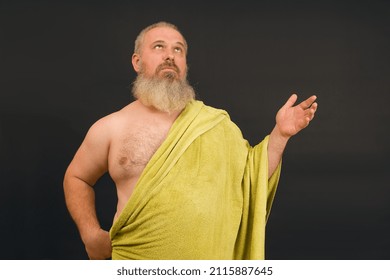 Nude Bearded Man Wearing A Towel Like A Greek God Waving His Hand Thoughtfully On A Black Background