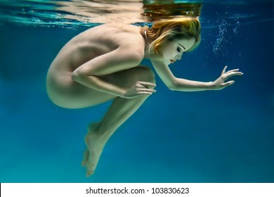 Nude beautiful girl is under water. Soft focus