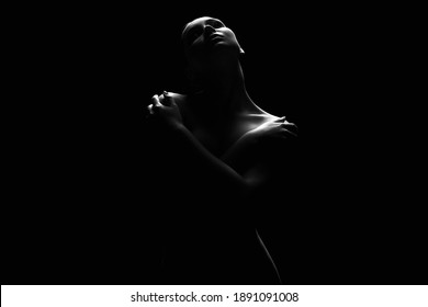Nude Woman silhouette under light in the dark. Beautiful Sexy Naked Body Girl