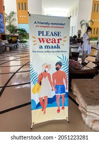 Nuevo Vallarta, Nayarit - Mexico - September 29 2021: Roll Up Sign Reminding To Wear A Mask During Epidemic Of Covid-19 At Grand Velas Hotel. Employee Woman Wearing Face Mask And Protective Goggles.