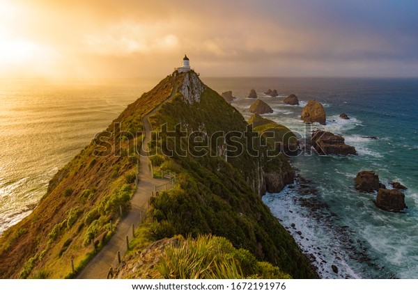 Nugget Point and lighthouse with sunrise at South\
Island, New Zealand
