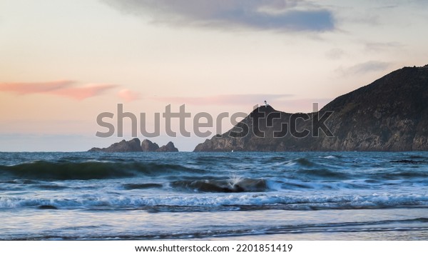 Nugget Point Lighthouse at sunrise, view from\
Kaka Point beach. Catlins,\
Southland.