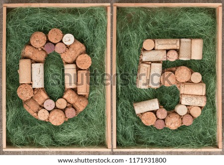 Number 05 zero five made of wine corks on green background in wooden box
