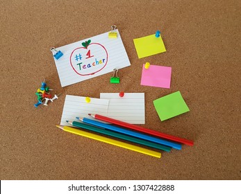 Number 1 Teacher Sign Pinned On A Cork Board, Note Pads And Colored Pencils Laying On A Cork Background, Teachers Appreciation Day, Thank You Teacher, Education, Memo Board