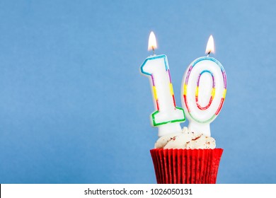 Number 10 Birthday Candle In A Cupcake Against A Blue Background