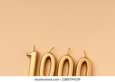 Number 1000 celebration festive background made with golden candles in the form of number Thousand. Universal holiday banner with copy space.