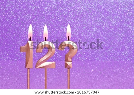 Number 12 and question mark on a pink background with blurred bright dots