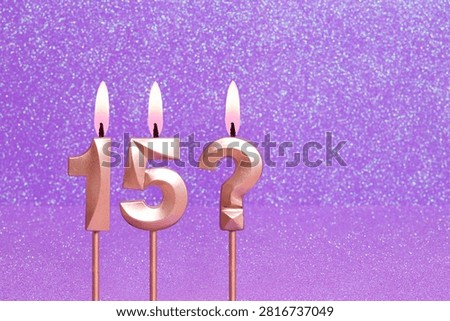 Number 15 and question mark on a pink background with blurred bright dots
