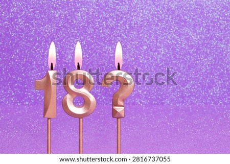 Number 18 and question mark on a pink background with blurred bright dots