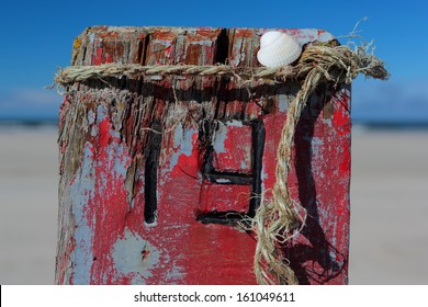 Number 19 On Old Wooden Pole On The Beach