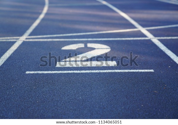Number 2 start position of an outdoor\
stadium running track with white dividing\
lines