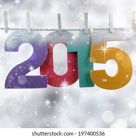 Number 2015 hanging on a clothesline in a glittery lights background - Powered by Shutterstock