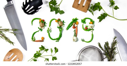 Number 2018 Written With Vegetables And Kitchen Utensils As Advertising Or Presentation In Food Industry, Menus, Brochures. Isolated On White Background. Happy New Year. End Of The Year Resolution