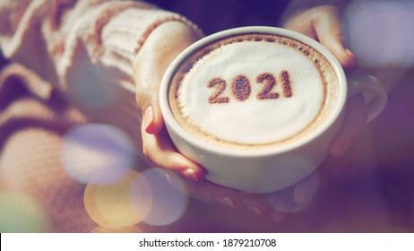 Number 2021 On Frothy Surface Of Cappuccino Served In White Cup Holding By Female Hands With French Nail Polish. New Year New You, Holidays Food Art Theme Happy New Year 2021. (selective Focus)