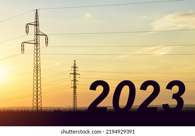 The Number 2023 With Electric Pylons At Sunset. Concept Of High Price Of Electricity Or Happy New Year.