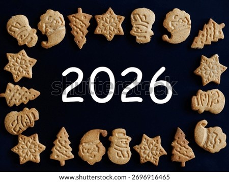 Number 2026 in frame of ginger bread cookies man snowman christmas tree star santa claus on black background. 2026 Happy New Year card