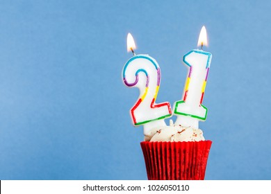 Number 21 Birthday Candle In A Cupcake Against A Blue Background