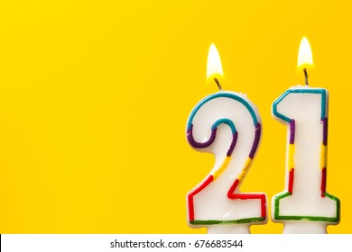 Number 21 Birthday Celebration Candle Against A Bright Yellow Background