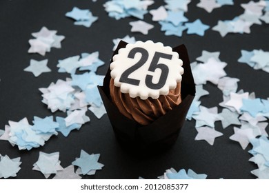 Number 25 on Delicious chocolate cupcake with cream on dark background. Muffin. Birthday cake party. Homemade Chocolate Cupcake. 25 years old anniversary