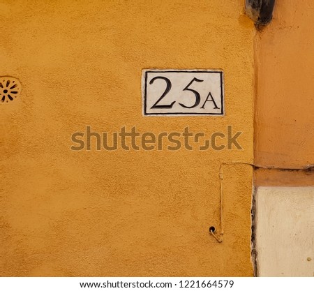 Number 25a (twenty five A) isolated on the yellow wall