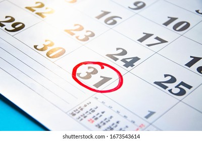 The number 31 in the calendar is circled in red circle on a blue background. A question mark near a number, everything around is dark. Calendar for plans, notes, meetings. Business calendar.