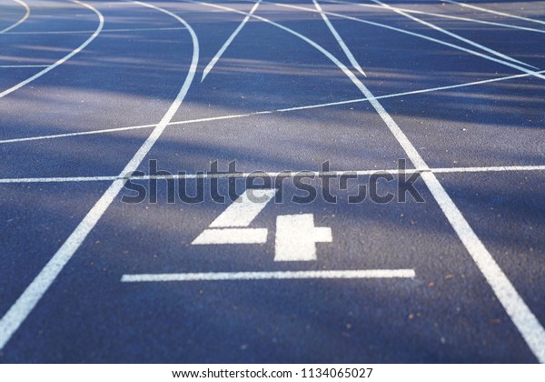 Number 4 start position of an outdoor\
stadium running track with white dividing\
lines