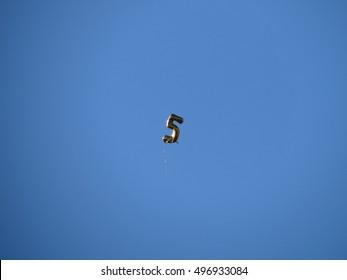 A Number 5 Balloon Floating Away On A Clear Sunny Day