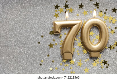 Number 70 gold celebration candle on star and glitter background - Shutterstock ID 742211563