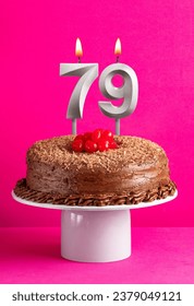 Number 79 candle - Chocolate cake on pink background