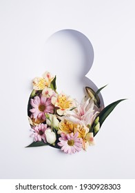 Number 8 with fresh spring flowers with green leaves on bright white background. Minimal Women's day, March 8th or birthday concept. Flat lay, top view.