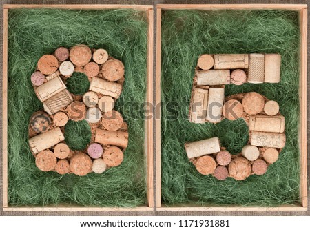 Number 85  eighty five made of wine corks on green background in wooden box