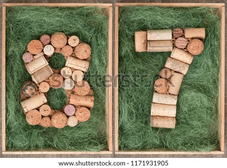 Number 87  eighty seven  made of wine corks on green background in wooden box