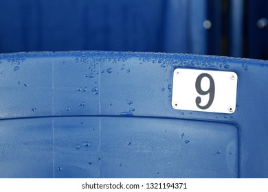 The Number 9 On A Blue Stadium Seat. Birthday Concept With Room For Text.