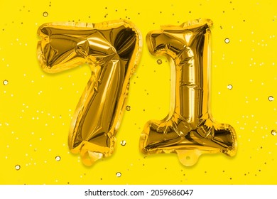 The number of the balloon made of golden foil, the number seventy-one on a yellow background with sequins. Birthday greeting card with inscription 71. Numerical digit, Celebration event, template.
