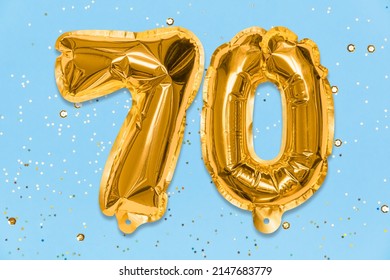 The number of the balloon made of golden foil, the number seventy on a blue background with sequins. Birthday greeting card with inscription 70. Anniversary concept. Celebration event. - Shutterstock ID 2147683779