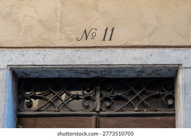Number eleven written in elegant script above an old stone doorway