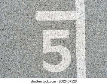 Number five painted on soft rubber surface. Jumping hopscotch game with numbers. The fifth possition. Safety outdoor playground