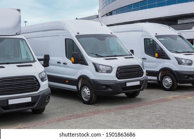 number of new white minibuses and vans outside